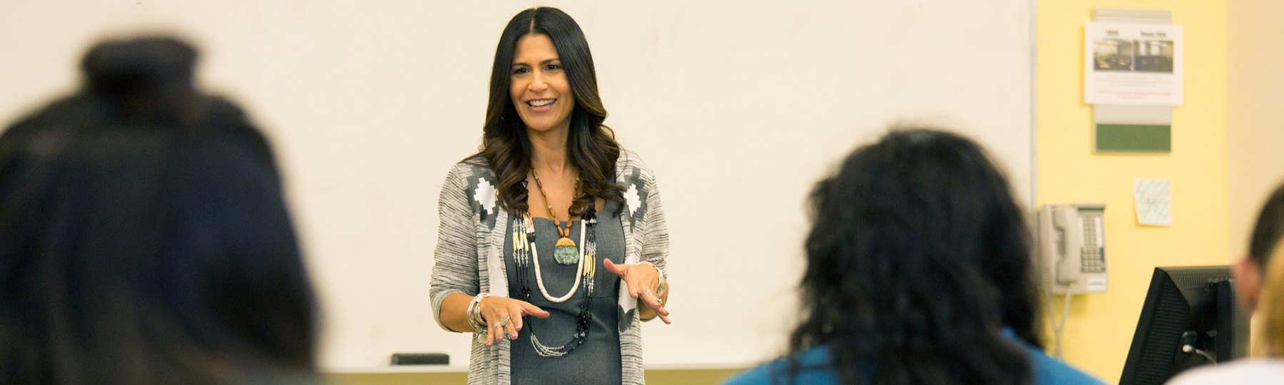Native American teacher teaching in front of classroom