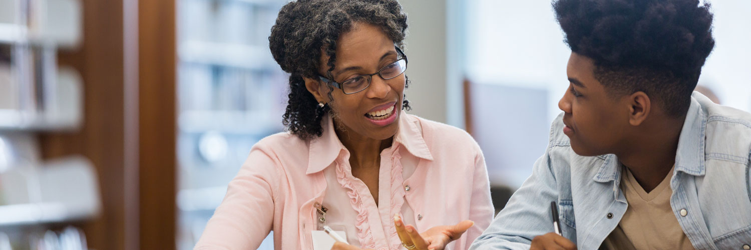 Black, female teacher with student